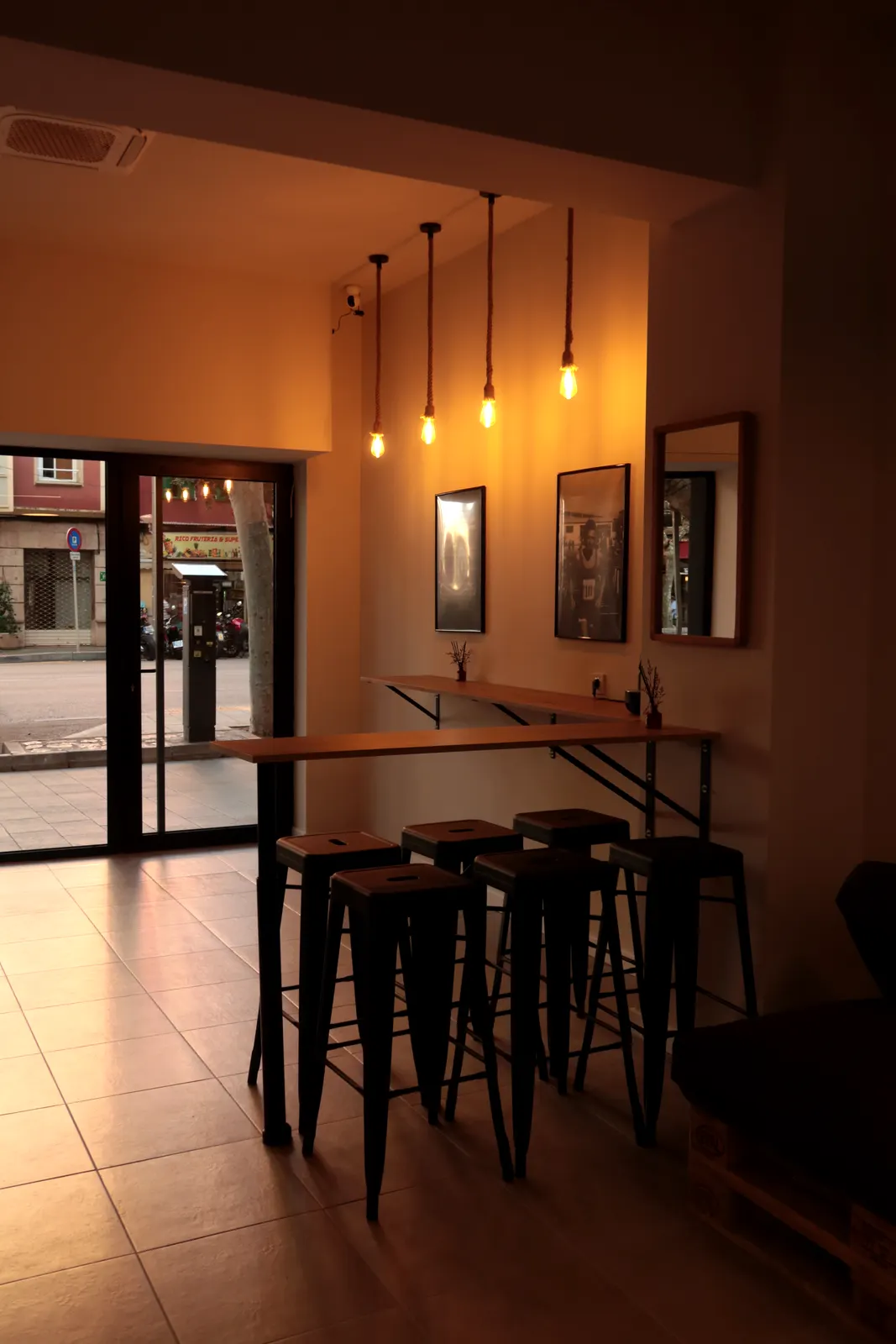 Zona chillout interior con barra y taburetes junto a la entrada